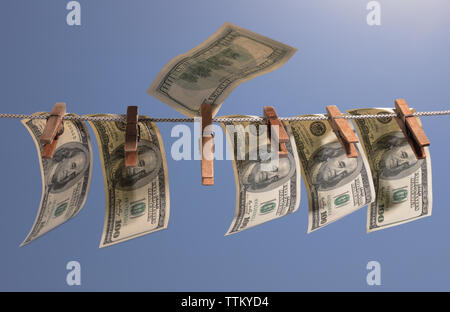 Geld hängen an einer Wäscheleine mit alten hölzernen Wäscheklammern. Das Symbol der Offshore Anlagen, Wirtschaftskriminalität und Geldwäsche. Stockfoto