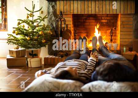 Paar hält die Hände am Kamin zu Hause ausruhen Stockfoto