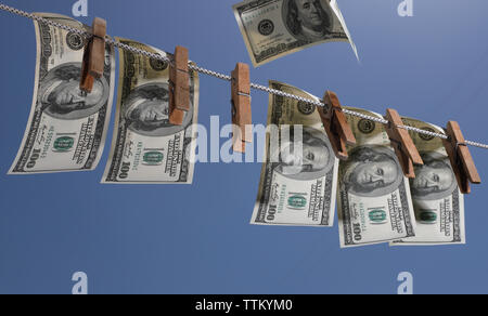 Geld hängen an einer Wäscheleine mit alten hölzernen Wäscheklammern. Das Symbol der Offshore Anlagen, Wirtschaftskriminalität und Geldwäsche. Stockfoto