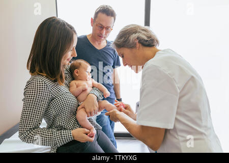 Ärztin untersuchen baby boy mit Eltern im Krankenhaus Stockfoto