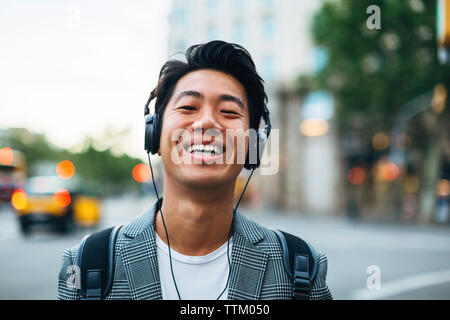 Portrait von Happy Geschäftsmann Musik hören in der Stadt Stockfoto