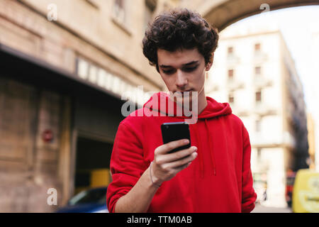 Teenager mit Smart Phone in der Stadt Stockfoto