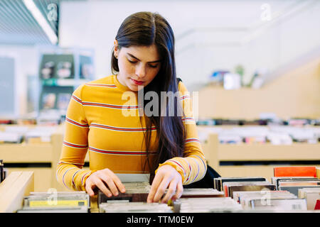 Frau suchen buchen Sie im Regal in der Bibliothek Stockfoto