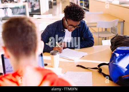 Hohe Betrachtungswinkel männliche Freunde studieren am Tisch in der Bibliothek Stockfoto