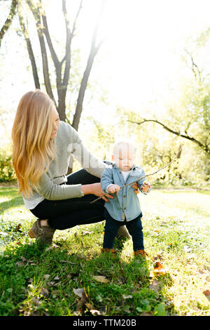 Eine Mama hilft Ihr Baby Sohn stand Stockfoto