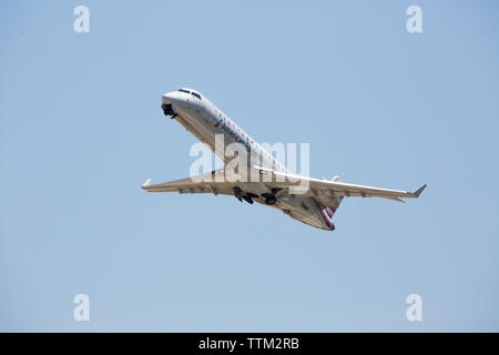 Eine American Eagle Passagierflugzeug zieht seine Fahrwerk kurz nach dem Weg vom Charlotte-Douglas International In einer wolkenlosen, blauen Himmel. Stockfoto