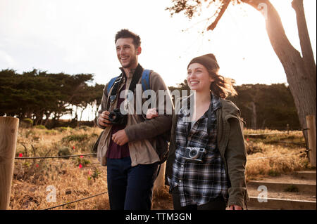 Gerne wandern Paar Arm in Arm auf dem Feld Stockfoto