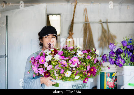 Frau mit Korb mit Blumen in der Werkstatt Stockfoto