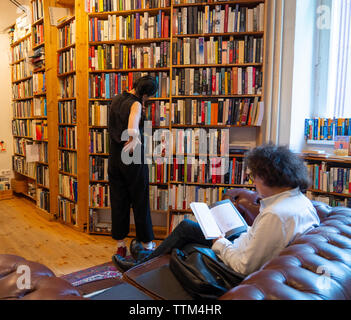 Mann lesen Buch in St Georges secondhand Buchladen im Prenzlauer Berg, Berlin, Deutschland Stockfoto