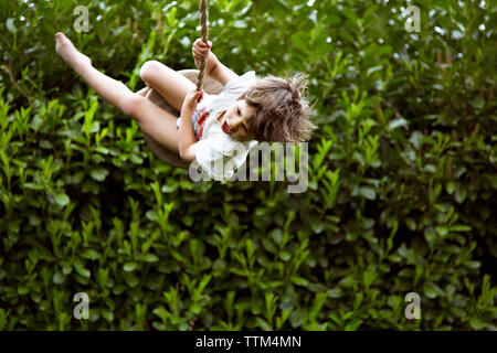 Happy Boy schwingen im Garten Stockfoto