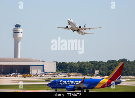 Ein American Airlines Boeing 737 Verkehrsflugzeuge zieht aus internationalen Flughafen Charlotte-Douglas während ein Southwest Airlines Jet wartet. Stockfoto