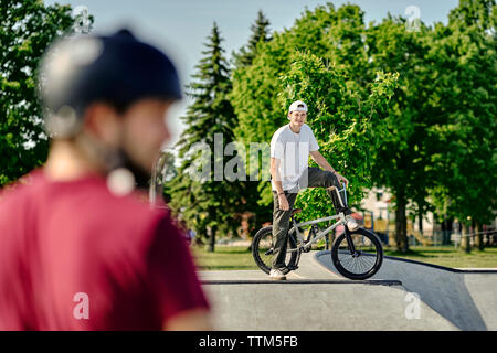 Portrait von BMX-rider auf konkrete Rampe bei skateboard Park während der sonnigen Tag Stockfoto