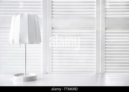 Stilvolle Lampe auf weißem Folding Screen Hintergrund Stockfoto