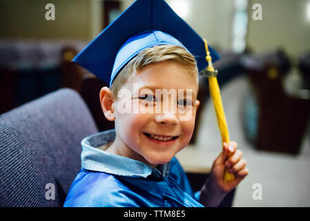 Portrait von Happy Boy an der Staffelung kleid Standortwahl auf Stuhl Stockfoto