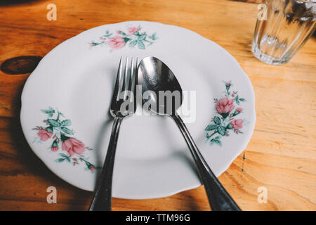 Hohe Betrachtungswinkel von Bestecken mit Platte auf hölzernen Tisch Stockfoto