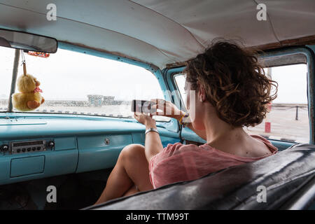 Western Mädchen allein einen selfie in einem alten Oldtimer in Kuba Stockfoto