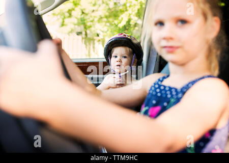 Portrait von cute junge sitzt mit Schwester im Auto. Stockfoto