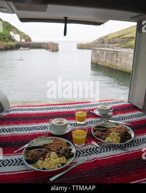 Hohe Betrachtungswinkel von Nahrungsmitteln im Motor home gegen Meer serviert Stockfoto