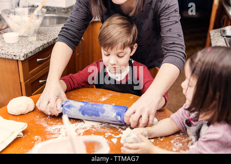Mutter und Kinder gemeinsames Kochen in der Küche Stockfoto