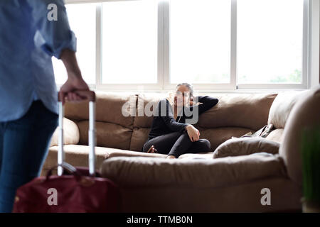 Lächelnd Freundin, Freund beim Sitzen auf einem Sofa in vermietung haus Stockfoto