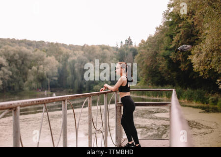 Weibliche Jogger auf Pier am See Stockfoto