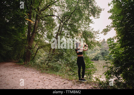 Weibliche Jogger fotografieren See im Park Stockfoto