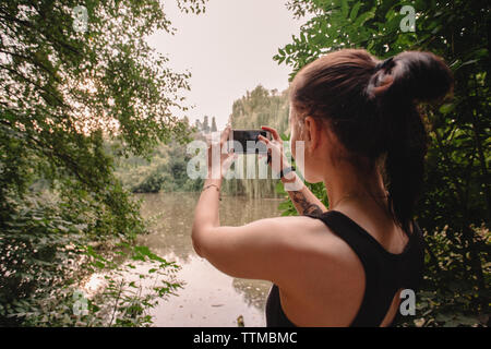 Ansicht der Rückseite Frau unter Bild der See im Park Stockfoto