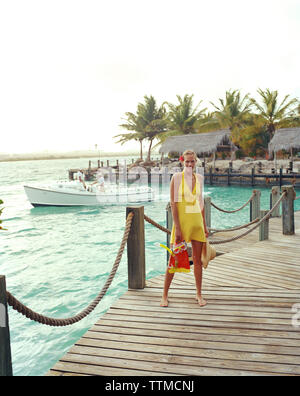 ARUBA, Porträt der jungen Frau, die auf einem Dock mit ihrer Schnorchelausrüstung, Renaissance Insel Stockfoto