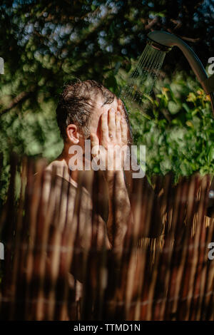 Foto des Menschen unter einer Dusche im Freien Stockfoto