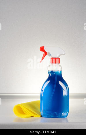 Glasreiniger mit einem Lappen auf dem grauen Tabelle Stockfoto