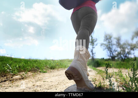 Weibliche Wanderer gehen den Hügel hinauf, an einem sonnigen Tag Stockfoto