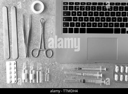 Medizinische Werkzeuge mit Laptop auf grauem Hintergrund Stockfoto