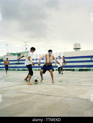 Mexiko, Riviera Maya, Halbinsel Yucatan, junge Männer spielen Fußball in der Stadt von Akumal Stockfoto