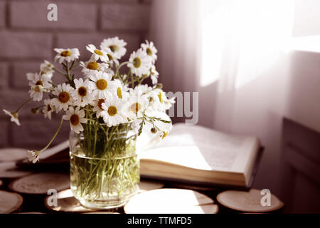 Kamille Blumenstrauß in Glas Vase auf Holz- Hintergrund Stockfoto