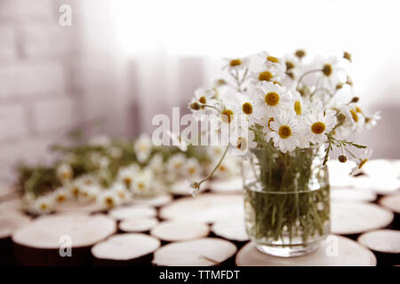 Kamille Blumenstrauß in Glas Vase auf Holz- Hintergrund Stockfoto