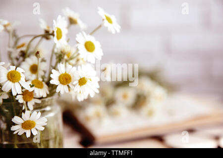 Kamille Blumenstrauß in Glas Vase auf unscharfen Hintergrund Stockfoto