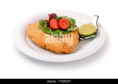 Lecker steak in Paniermehl Panko und frisches Gemüse Salat und Kalk auf einem Teller, auf weißem Hintergrund Stockfoto