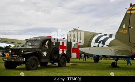 1942 Dodge WC 54 Krankenwagen neben einem 1944 C-47 Dakota" Betsy's Biscuit Bomber" an Shuttleworth den 75. Jahrestag des D-Day zu gedenken geparkt. Stockfoto