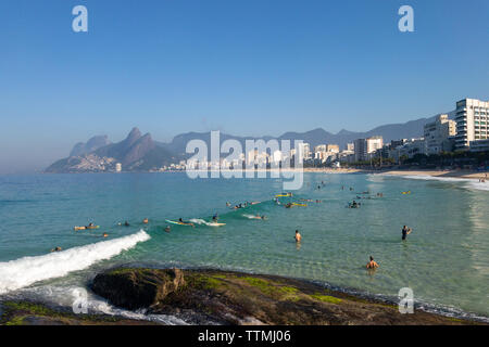 Rio de Janeiro, Brasilien - 15. Juni 2019: Arpoador, Ipanema Strand in einer ruhigen Samstag Morgen mit klaren Wasser, blauer Himmel, Surfer und eine kleine Welle. Stockfoto