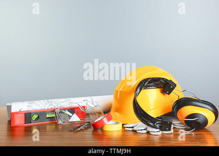 Bauplänen mit Werkzeugen und Helm auf hellen Hintergrund Stockfoto