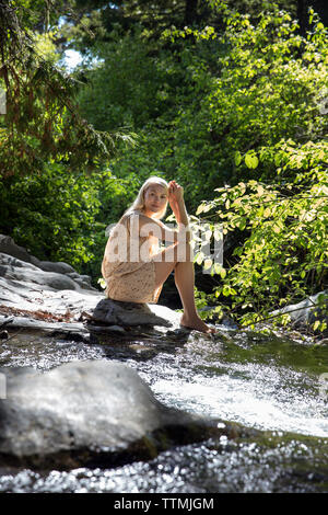 USA, Kalifornien, Big Sur, Esalen, eine Frau sitzt, die von Hot Springs Creek am Esalen Institut Stockfoto