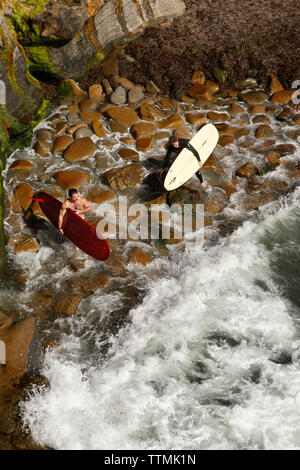 USA, Kalifornien, San Diego, zwei Surfer bereiten das Wasser entlang Sunset Cliffs im Ocean Beach eingeben Stockfoto