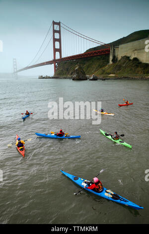 USA, Kalifornien, San Francisco, Personen ertragen die Kälte unter der Golden Gate Bridge zu Kajak Stockfoto