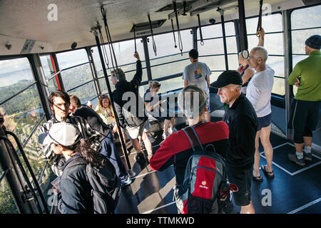 Kanada, Vancouver, British Columbia, reiten Sie auf Grouse Mountain Skyride Gondel mit der Stadt Vancouver in der Ferne Stockfoto