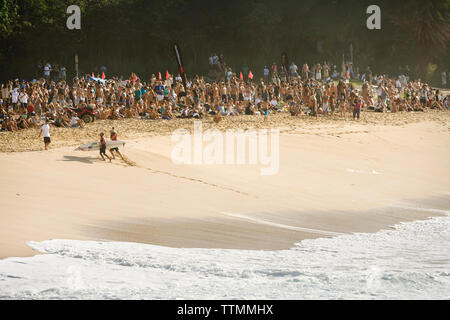 USA, Hawaii, Menge Uhren Ramon Navarro am Strand laufen nach dem Surfen eine riesige Welle, Waimea Bay, Oahu Stockfoto