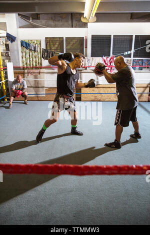 USA, Oahu, Hawaii, MMA Mixed Martial Arts Ultimate Fighter Lowen Tynanes Züge und spieren an seiner Turnhalle in Honolulu. Stockfoto