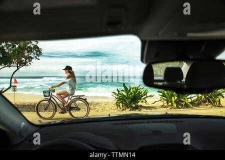 USA, Hawaii, Oahu, Northshore, eine junge Frau, reiten ihr Fahrrad auf dem Weg entlang der Sunset Beach Stockfoto