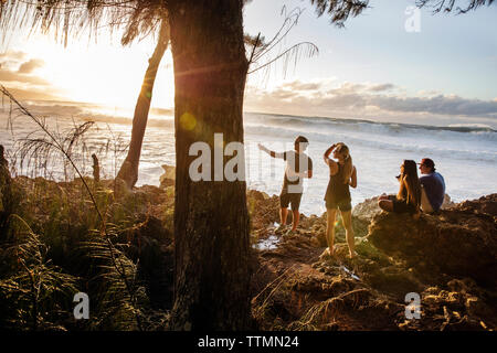 HAWAII, Oahu, North Shore, Umstehende sehen Sie eine große Rolle in Schwellen bei Sonnenuntergang an pupukea Beach Park an der Nordküste Stockfoto