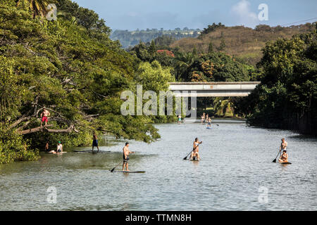 HAWAII, Oahu, North Shore, Reisende auf der paddleboarding Anahulu Fluss unterhalb des historischen Rainbow Bridge in der Stadt Haliewa Stockfoto