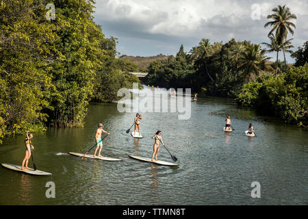 HAWAII, Oahu, North Shore, Reisende auf der paddleboarding Anahulu Fluss unterhalb des historischen Rainbow Bridge in der Stadt Haliewa Stockfoto